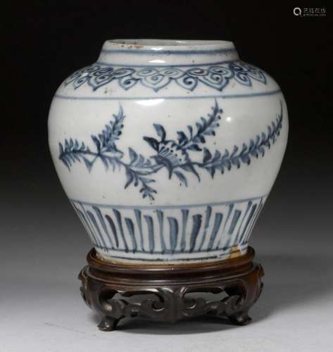 A SMALL UNDERGLAZE BLUE-DECORATED JAR SHOWING FLOWERING BRANCHES BETWEEN RUYI AND LOTUS LEAF BORDERS. China, Ming Dynasty, H 10.5 cm. Wooden base. Minor cracks.