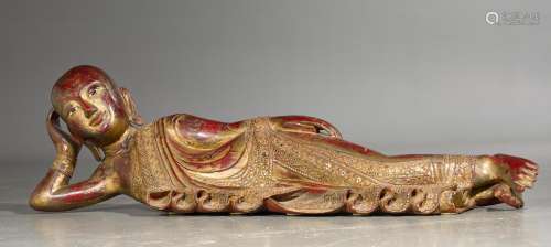 A LACQUERED WOODEN RECUMBENT BUDDHA (PARINIRVANA). Burma, Mandalay, 19th/20th c. L 130 cm. With inlaid eyes and mirror appliqués. Minor damage.