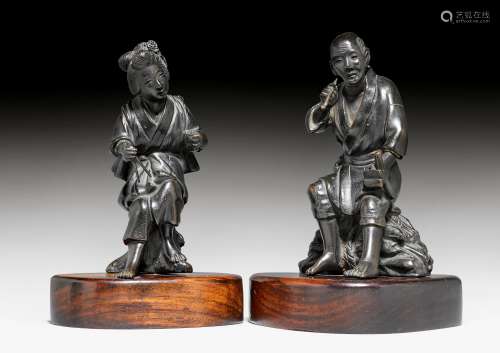 TWO BRONZE FIGURES OF A RESTING COUPLE.