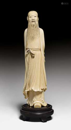 A FINE IVORY CARVING OF A STANDING SCHOLAR.