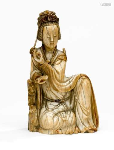 A VERY FINELY CARVED IVORY MODEL OF GAUNYIN AND ROCK