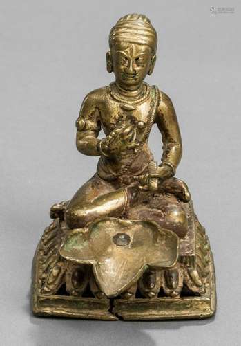A BRASS OIL-LAMP, Nepal, 19th Ct., the leaf-shaped oil container set to a lotus base cast with a seated male figure holding a rosary and a manuscript, wearing dhoti, bejewelled and his head covered with a turban - Very minor wear, short tear to base