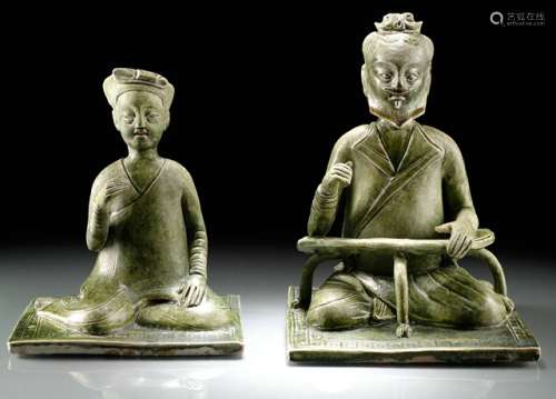 TWO UNUSUAL GREEN GLAZED POTTERY FIGURES OF A SITTING WOMAN AND A MAN, China, Northern Qi dynasty, 2nd half of the 6th ct. On a framed mat with crossed legs and lightly raised right arms. The bearded man supplemented by a crescent-shaped tripod armrest with paw-shaped legs and animal-head terminals, the nearly white clay covered overall with a deep green glaze, their mouths with traces of red pigment. The two figures are very unusual both in style and their material. Age measurement of the male figure confirmed by Thermoluminescence Analysis 7th April 2008 (Oxford Authentication, no. C108e86). - Provenance: Bought in 1997 from L.H.W. Investment & Trading Limited, Hong Kong. - Described and illustrated in: Regina Krahl: Collection Julius Eberhardt. Early Chinese Art, vol. 1, Hong Kong 1999, pp. 45 and 204f.