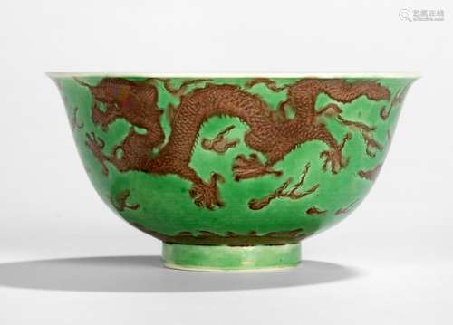 A FINE INCISED GREEN-GROUND AUBERGINE-ENAMELLED 'DRAGON' BOWL, China, underglaze blue six-character mark Kangxi and of the period, the exterior is finely incised and enamelled in aubergine with a pair of scaly dragons amidst clouds in pursuit of flaming pearls, striding above crashing waves breaking against stylised rocks, all against an emerald-green enamel ground - Property from a Berlin private collection, bought in the 1970s from Sotheby's London - Hairline to rim