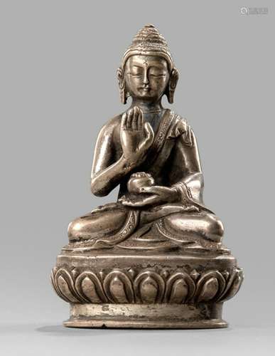 A SILVER FIGURINE OF BUDDHA SHAKYAMUNI, NEPAL, 19th ct., seated in vajrasana on a lotus base with his right hand in abhayamudra while the left is supporting the alms-bowl, wearing a monastic garb and his face is displaying a serene expression, sealed - Property from an old German family collection, assembled in China around 1912 - Minor wear