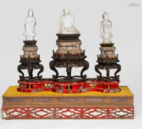 A GROUP OF THREE ROCK CRYSTAL FIGURES MOUNTED ON A FINELY CARVED HARDWOOD STAND ABOVE A BASE, China, the figures 19th ct. - Property from an old Austrian private collection - One head re-stuck, very slightly chipped