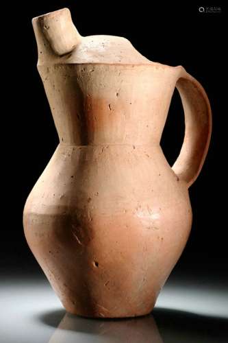 A POTTERY EWER, China, Neolithic, Qijia culture, first half of the 2nd millennium BC. With an ovoid body, a tapering neck with domed top, double-lobed opening and tubular spout, flat strap handle. Tool marks. Age measurement confirmed by Thermoluminescence Analysis 30th November 1998 (Oxford Authentication, No. C289h99). - Provenance: Bought in 1997 from L.H.W. Investment & Trading Limited, Hong Kong. - Described and illustrated in: Regina Krahl: Collection Julius Eberhardt. Early Chinese Art, vol. 1, Hong Kong 1999, p. 64f. For a similar pottery ewer see Okazaki Takashi: Ceramic Art of the World, vol. 10: Chinese Prehistoric and Ancient Periods, Tokyo 1982, pl. 130.