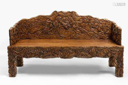 A FINE CARVED HARDWOOD BENCH WITH DENSE ALLOVER PATTERN OF LOTUS BLOSSOMS, LEAVES AND BUDS HIDING CRANES, China - Arm rests, back rest and feet decorated with relief carving on the front and reverse sides, plain seat - Property from an Austrian private collection - Reverse side without finish, traces of use