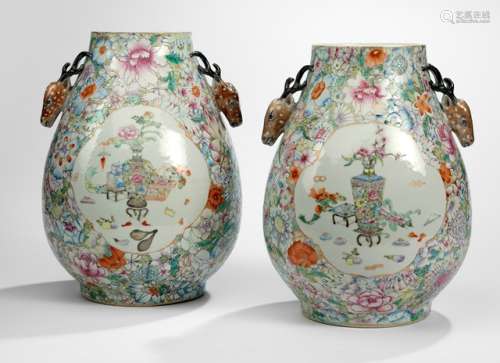 A PAIR OF 'HU'-SHAPED 'MILLE FLEUR' VASES WITH STAGHEAD HANDLES, China, Guangxu/Republic period. - Property from a South German private collection, assembled in the 1990s - One vase with rep. fracture from bottom across the wall, one vase with minor chips to the stag antlers, minor wear