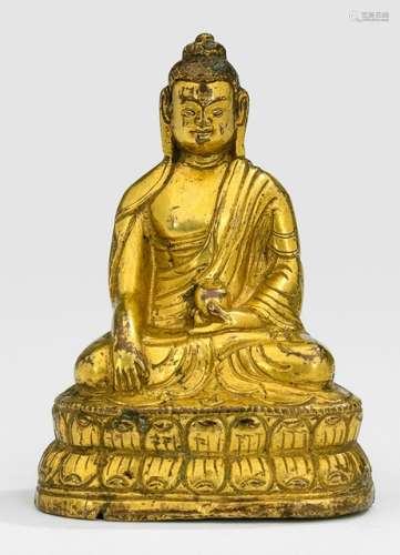 A GILT-BRONZE FIGURE OF BUDDHA SHAKYAMUNI, Tibet, early 19th ct., seated in vajrasana on a lotus base with his right hand in bhumisparshamudra while the left is resting on his lap supporting the alms-bowl, wearing a monastic garment and his face is displaying a serene expression, unsealed - Property from a German private collection, assembled in the 1970s and 80s - Minor wear