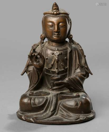 A BRONZE FIGURE OF A GUANYIN, China, ca. 18th ct. Seated in vajrasana, the left hand holding an alms bowl, his hair in two plaits falling over his shoulders, the face with a serene expression - Property from a South German private collection, assembled in the 1990s - Remnants of gilding, minor wear