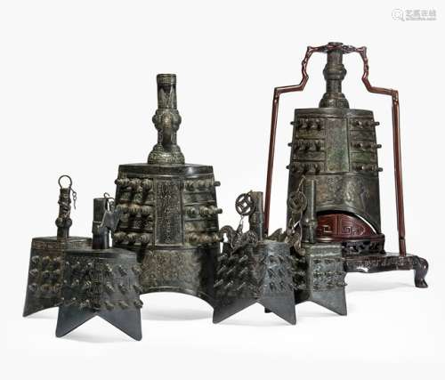 A GROUP OF SIX BRONZE BELLS IN ARCHAIC STYLE, China, Qing dynasty, one with craved hardwood stand - Provenance: Property from an old diplomat collection, assembled in China prior to 1970 - Minor wear, very slightly chipped