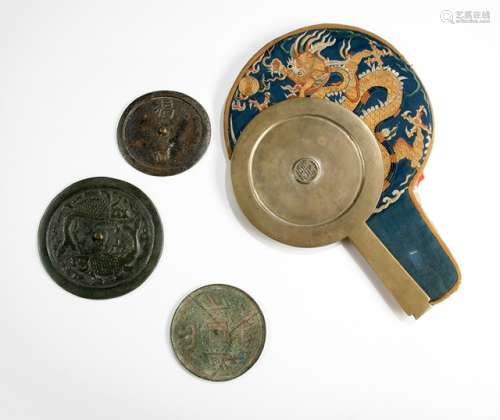 A GROUP OF FOUR BRONZE MIRRORS AND AN EMBROIDERED MIRROR COVER, China, Ming dynasty and later - Three traditional mirrors with bridge-shape knobs, the obverse decorated with a pair of fish / emblems of good luck and outcome (deer), one bearing the design of the Han dynasty 'mountain' character, so called 'shan zi jing'. One Huzhou style mirror with handle - Property from an old German private collection, in Germany since 1963 - Dark patination, the 'shan zi jing' restuck