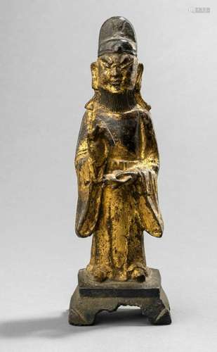 A GILT- AND BLACK-LACQUERED BRONZE FIGURE OF AN OFFICIAL, CHINA, 17th ct., standing on a rectangular pedestal, both hands holding pencil and scroll, wearing various garments, his face displaying a severe expression, beard and his head topped with a hat - Property from an old Dutch private collection, assembled from 1950 till the 1990s, by descent to the present owner - Minor wear