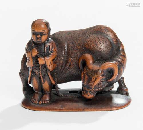 A WOOD NETSUKE OF A BOY WITH AN OX