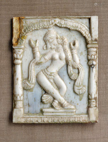 A CARVED IVORY PLACQUE DEPICTING A FEMALE DANCER