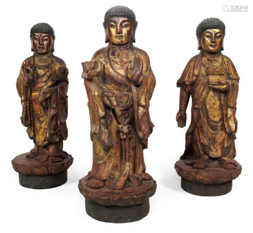 THREE RED AND GOLD LACQUER PAINTED WOOD BUDDHAS