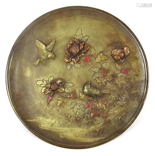 A METAL PLATE WITH PAINTED BLOSSOMS AND TWO BIRDS IN RELIEF