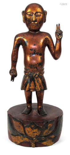 A WOODEN FIGURE WITH GOLD AND RED LACQUER PAINTING