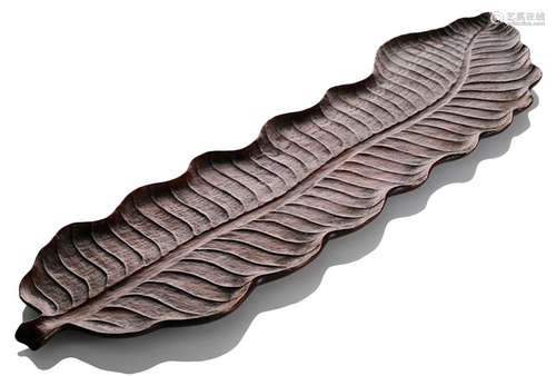 A WOOD TRAY IN SHAPE OF A BANANA LEAF