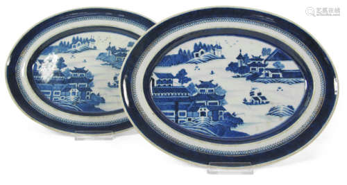 TWO BLUE AND WHITE PORCELAIN PLATES DEPICTING A RIVER LANDSCAPE AND ARCHITECTURE
