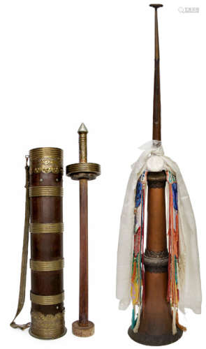 A COPPER TAPERING TELESCOPIC HORN DECORATED WITH SCARFS AND ORNAMENTS AND A METAL EMBELLISHED WOOD BUTTER POUNDER IN CYLINDRICAL CONTAINER