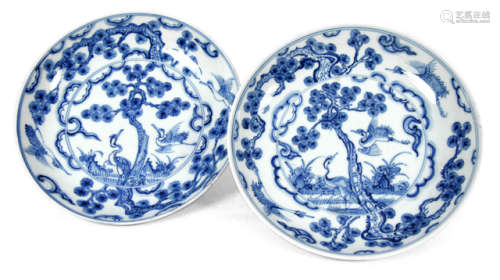 A PAIR OF BLUE AND WHITE PORCELAIN DISHES DEPICTING TWO CRANES UNDER A PINE