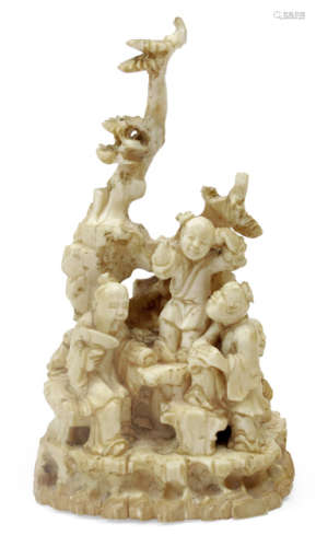 A CARVED IVORY GROUP OF A  SCHOLAR AND CHILDREN NEXT A PINE TREE