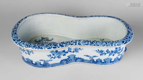A large Chinese porcelain bidet, Qianlong period, painted in underglaze blue with chrysanthemum and peony sprays, the everted rim painted with scrolling lotus blooms, flat, unglazed base, 60cm long, 35cm wide