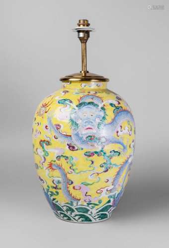 A Chinese porcelain famille rose jar, Republic period, painted in enamels with dragons on a yellow ground above crashing waves, 34cm high