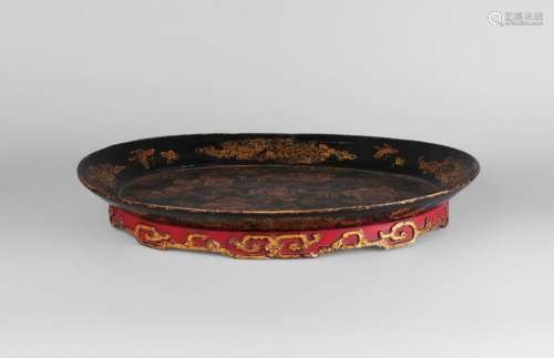 A large Chinese oval tray, 18th/19th century, the top surface decorated with Buddhist lions amidst clouds, the foot carved in relief with archaistic motifs, 53cm x 40cm