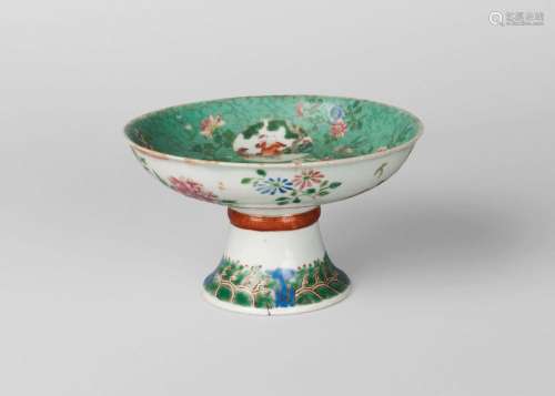 A Chinese porcelain stem bowl, Jiaqing mark and period, finely painted in famille rose enamels, the inside of the bowl decorated with three circular panels decorated with boys, one holding a peach, another holding a crab, painted to the underside with peony and narcissus, the stem with raised band painted with Greek key design on a coral ground, the base painted with crashing waves, underglaze blue seal mark to inside of base, 9cm high, 16cm diameter Cf. For similar examples, see a pair of bowl