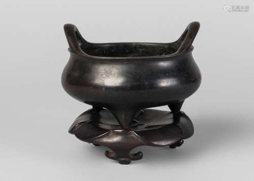 A Chinese bronze tripod censer and stand, Xuande mark but 18th century, of bombe form, with loop handles, six-character mark to base, on cast lotus base, 13cm diameter, 12cm high (including stand)