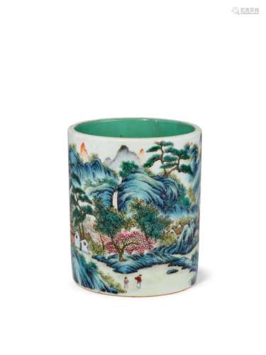 A rare Chinese porcelain famille rose brush pot, Qianlong mark and period, finely painted in enamels with a continuous extensive landscape, two women in conversation below a cherry blossom tree, amidst pine trees issuing from rocks, the interior with turquoise glaze, broad unglazed foot around recessed turquoise glazed base with iron-red seal mark, 10cm high, 8.5cm diameter Notes: Idealised landscape scenes like this are rare on Qianlong porcelain. Extensive landscapes of this nature were appl