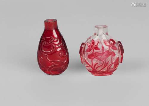 Two Chinese glass snuff bottles, late Qing dynasty, one cameo carved with lotus, 6cm high, the other carved with two stylised phoenix, 7cm high (2)