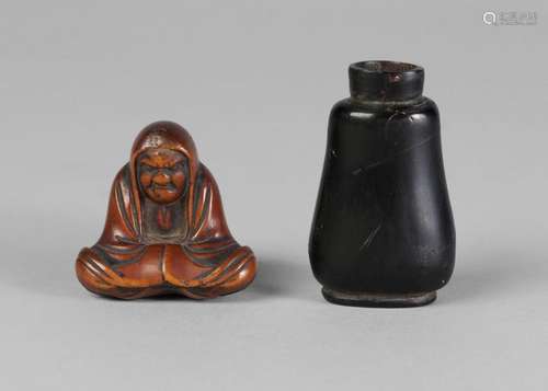 A Japanese boxwood seated Lohan, 19th century, and a Chinese ebonised snuff bottle (lacking stopper), 3.4cm high and 5cm high (2)