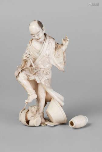 A Japanese ivory okimono of a potter, late 19th century, carved standing, holding a pot and a brush, whilst about to tread on a jar from which a cat emerges,13.5cm high