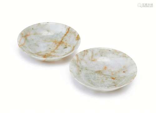 A pair of Chinese grey jadeite shallow bowls, 19th century, the translucent stone with brown veined inclusions, straight short footrim, the base inscribed with collection number, 11.5cm diameter