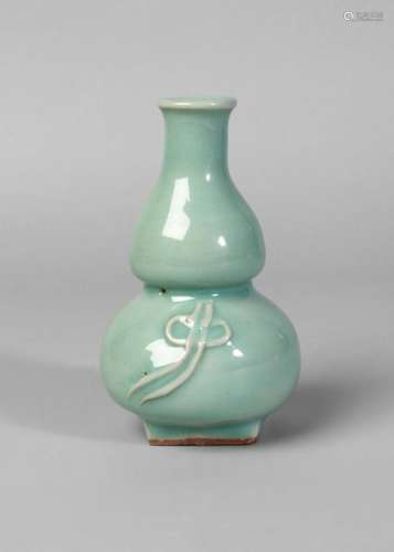A Chinese Longquan gourd-shaped 'birthday' vase, Song/Yuan Dynasty, with thick pale green-blue glaze, slightly everted rim and moulded to lower half with a tied ribbon, square, unglazed foot, glazed base, 13.5cm high, in Japanese wooden box Provenance: Private Japanese Collection in Italy