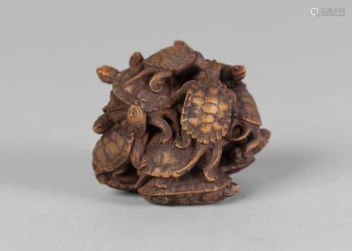 A fine Japanese carved wood turtle group netsuke, early 20th century, carved as thirteen turtles clambering upon eachother, signed, 4cm high