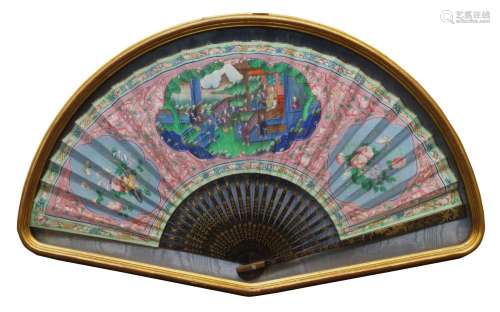 A Chinese export painted fan, late 19th century, with gilt painted papier mache sticks, the fan painted with a panel depicting ladies in a garden landscape, their heads of painted ivory, on a puce ground decorated with Buddhist emblems, 36cm long, in display case