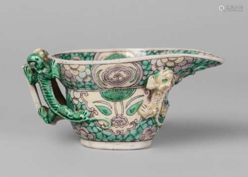 A Chinese porcelain archaistic libation cup, Kangxi period, painted in famille verte enamels with tao-tie masks and prunus blossom, applied with four chi-long dragons, 11cm long