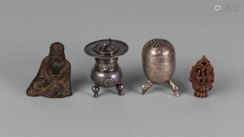A Chinese parcel-gilt bronze scroll weight, 17th/18th century, cast asa a seated scholar clutching a scroll, 4.5cm high, two Chinese silver miniature pepper shakers, 4.5cm high, and a carved nut bead (4) Provenance: Distinguished Midlands Collection