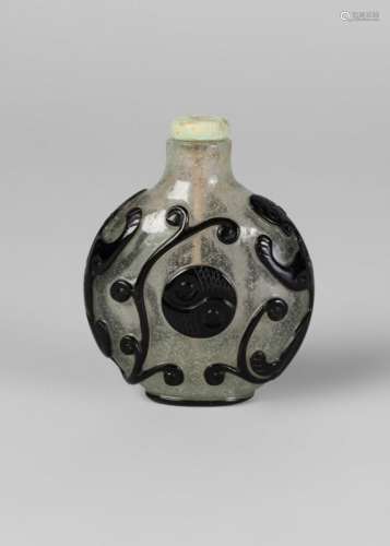 A Chinese glass overlay snuff bottle, late 19th century, of compressed disc form, with black overlay depicting two chi-long dragons encircling a yin yang symbol, 6.5cm high, associated stopper