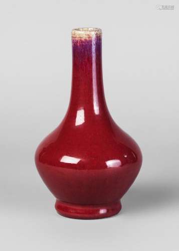 A Chinese grey stoneware sang de boeuf bottle vase, Qianlong period, the narrow, elongated neck with mushroom tone to rim, fading to purple, then a rich red, unglazed, unmarked, burnished base, 21cm high