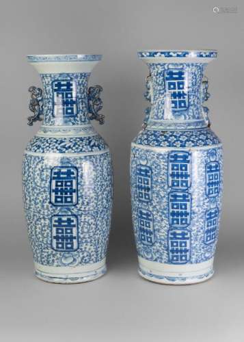 Two similar large Chinese porcelain baluster vases, late 19th century, painted in underglaze blue with scrolling peony blooms and double happiness symbols, one with pierced handles, the other with lion handles, 61cm high