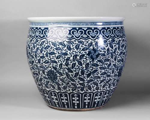 A large Chinese porcelain fish bowl, Daoguang period, painted in underglaze blue throughout with interconnecting lotus blooms between borders of lappets and ruyi, unmarked, 48cm high, 52cm diameter