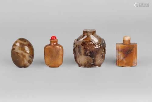 A Chinese agate snuff bottle, late 19th century, carved in low relief with the head of a tiger to one side and a perched hawk on the other, 7.5cm high, and three hardstone snuff bottles, one incised with blossom (4)