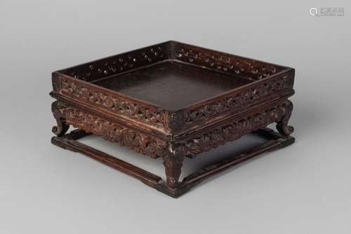 A Chinese hardwood square stand, late 19th century, with carved and pierced gallery and carved frieze decorated with scrolling lotus blooms, 21cm wide (VAT charged on hammer price)