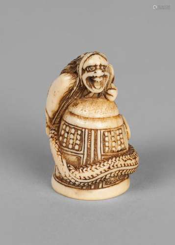 A Japanese ivory netsuke of Kiyohime atop the Dojoji bell, carved with tail coiled aaround the bell, unsigned, 4.5cm high